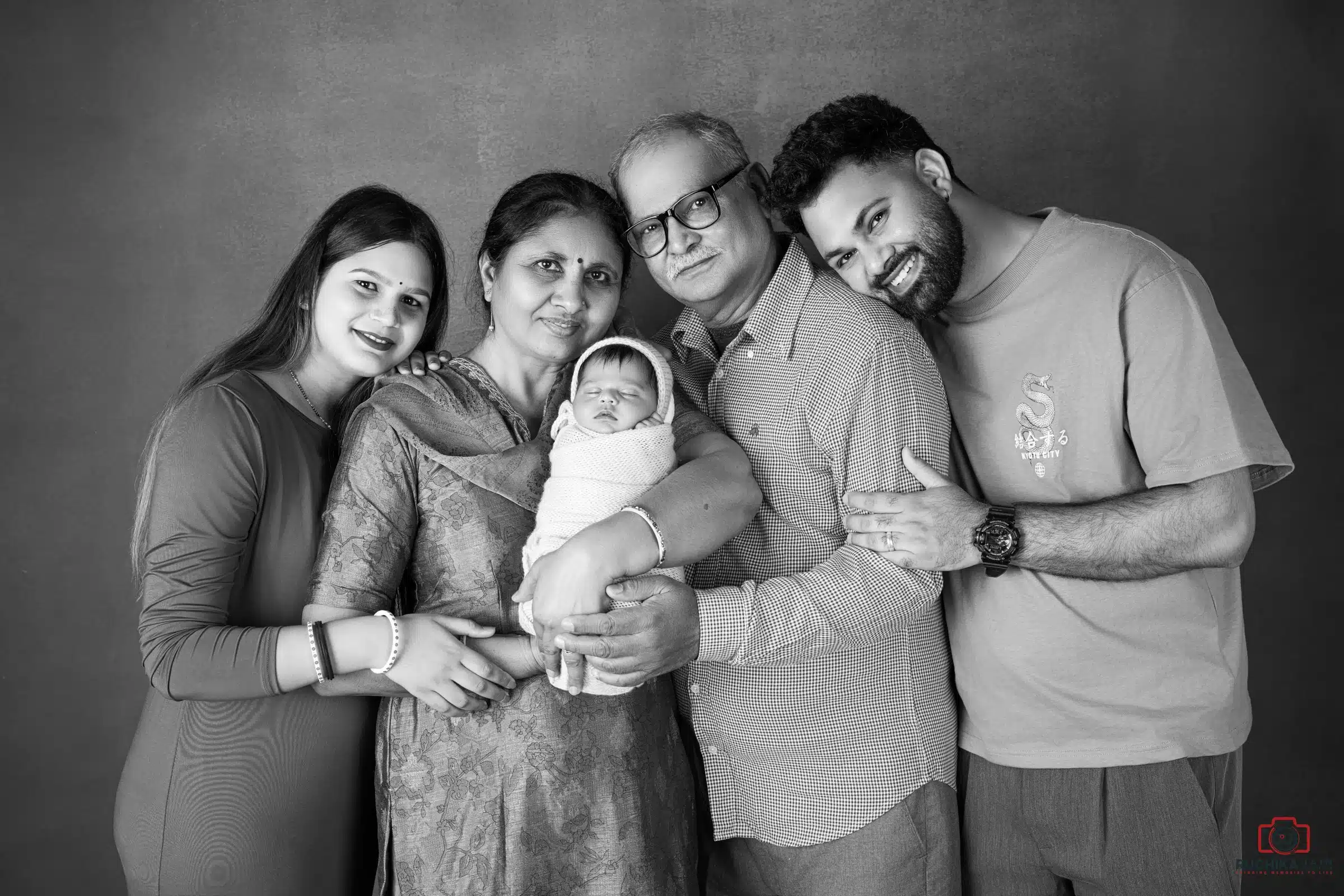 Family holding newborn baby during photoshoot – baby and family photography by Ruchika Jain Photography